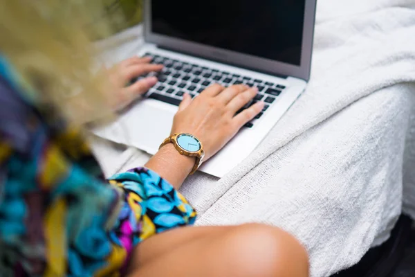 Woman freelancer, travel blogger works on a laptop. sitting on a — Stock Photo, Image