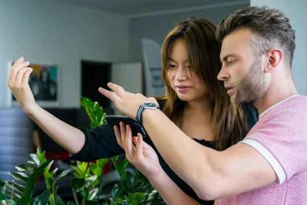 close up.boss shows colleagues information on the smartphone screen.  young people share news, show videos on a smartphone, discuss