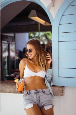 Güneş gözlüklü bir tatil bir kokteyl ile uzun saçlı güzel seksi kadın