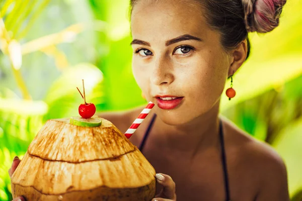 Mooie vrouwelijke drinken kokosnoot door een rietje, tropische Vaca — Stockfoto