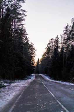 Karlı yol, karla kaplı kışın manzarası.
