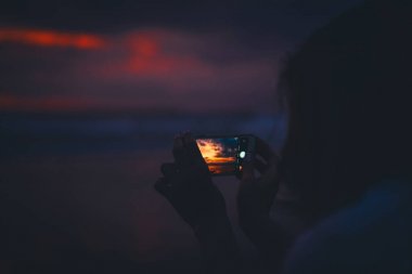 okyanusta akıllı telefon parlak güzel renk gün batımı fotoğraf çekmek kız