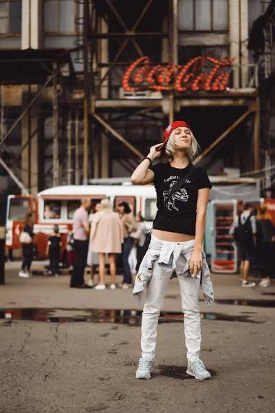 Una hermosa joven con un vaso de café sonríe y la —  Fotos de Stock