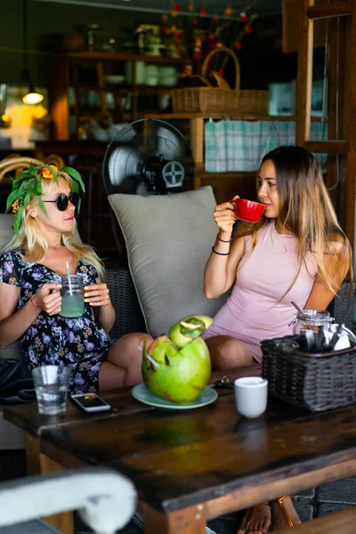 Two beautiful female friends having breakfast together in a cafe.