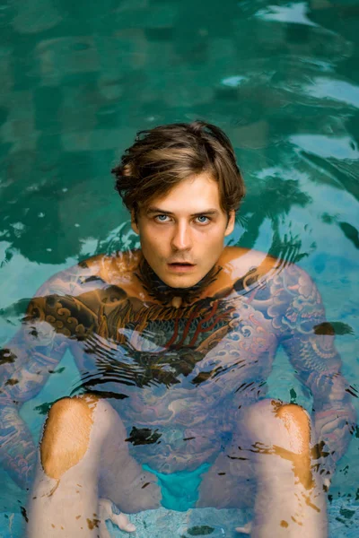 一个英俊男子在游泳池纹身的肖像 — 图库照片