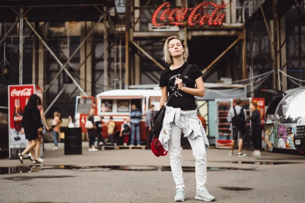 Een mooie jonge vrouw met een glas koffie glimlacht en La — Stockfoto