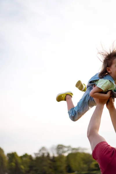 Liten flicka med pappa. Pappa kastar barnet upp i luften. gladlynt La — Stockfoto