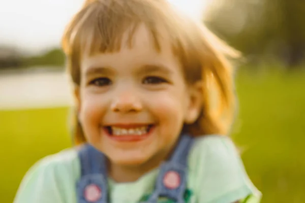 小女孩在蒲公英的田野上，在日落时分，情感快乐的气 — 图库照片