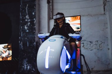 sanal gerçeklik gözlükleri. Sanal gerçeklik gözlüklü bir kız motosiklet yarışı yapıyor..