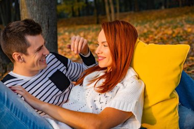 aşık genç çift. Sonbaharda parkta Aşıklar erkek ve kadın, şefkat, sarılma ve öpücük, mutlu çift.