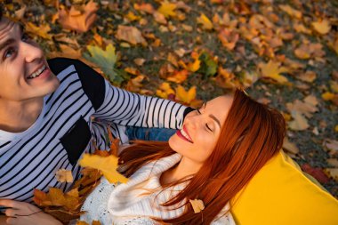 aşık genç çift. Sonbaharda parkta Aşıklar erkek ve kadın, şefkat, sarılma ve öpücük, mutlu çift.