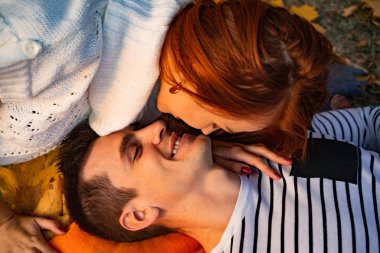 aşık genç çift. Sonbaharda parkta Aşıklar erkek ve kadın, şefkat, sarılma ve öpücük, mutlu çift.