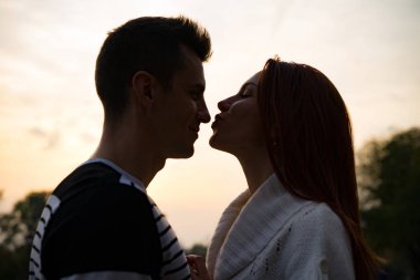 aşık genç çift. Sonbaharda parkta Aşıklar erkek ve kadın, şefkat, sarılma ve öpücük, mutlu çift.