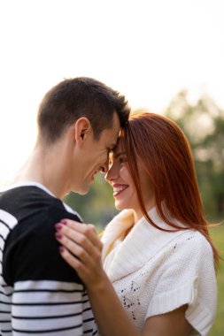 aşık genç çift. Sonbaharda parkta Aşıklar erkek ve kadın, şefkat, sarılma ve öpücük, mutlu çift.