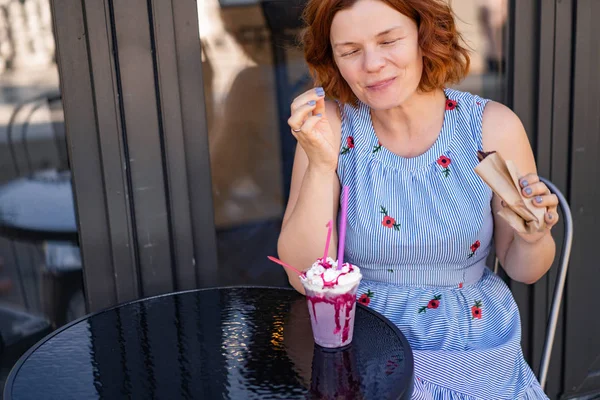 カフェで赤い髪の女性が夏のカクテルを飲んで幸せ笑い笑顔 — ストック写真