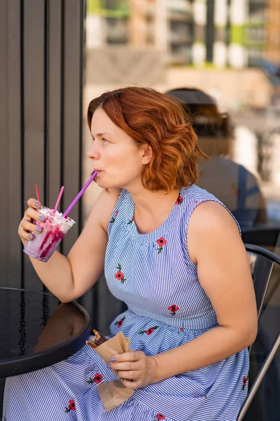 カフェで赤い髪の女性が夏のカクテルを飲んで幸せ笑い笑顔 — ストック写真