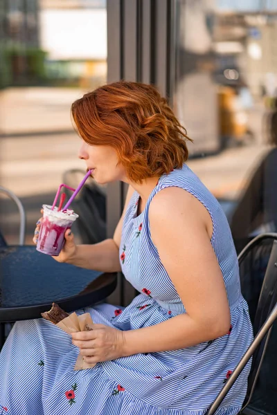 カフェで赤い髪の女性が夏のカクテルを飲んで幸せ笑い笑顔 — ストック写真