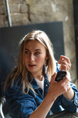 Kafede genç ve güzel bir kadın aynaya bakar. 