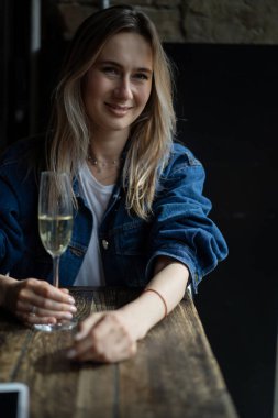 Bir kafede genç, güzel bir kadın, bir kadın şampanya içiyor.