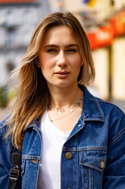 Genç, güzel bir kadın Avrupa 'da şehirde dolaşıyor, sokak fotoğrafı, şehir merkezinde poz veren bir kadın.