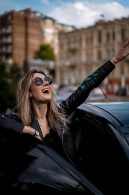 Genç ve güzel bir kadın arabada oturuyor.