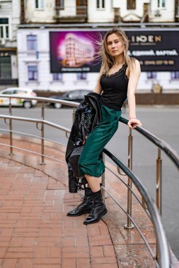 Genç, güzel bir kadın Avrupa 'da şehirde dolaşıyor, sokak fotoğrafı, şehir merkezinde poz veren bir kadın.