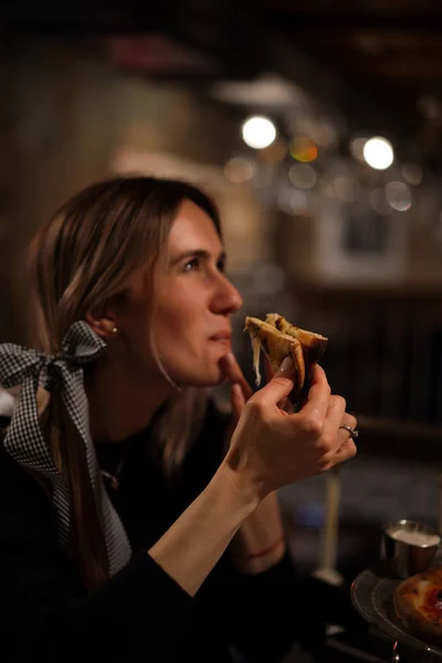若いです美しいです女性でザ ピッツェリア食べるジューシーなピザ — ストック写真