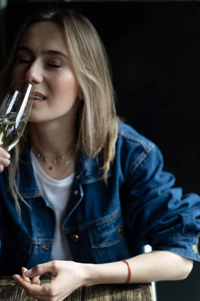 Jovem mulher bonita em um café, uma mulher bebendo champanhe em um — Fotografia de Stock