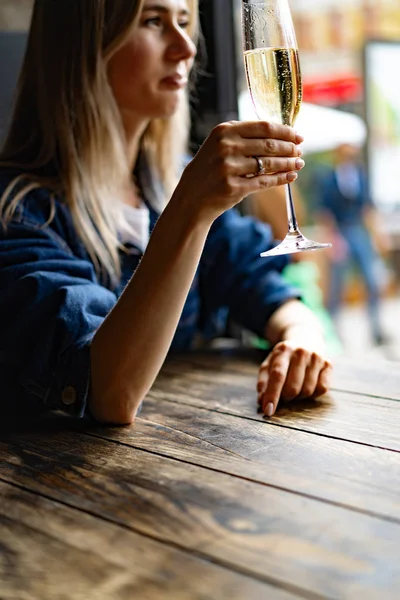 Fiatal gyönyörű nő egy kávézóban, egy nő pezsgőt iszik egy — Stock Fotó
