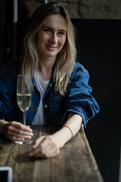 Giovane bella donna in un caffè, una donna che beve champagne in un — Foto Stock