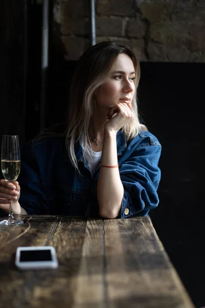 Молодая красивая женщина в кафе, женщина пьет шампанское в — стоковое фото