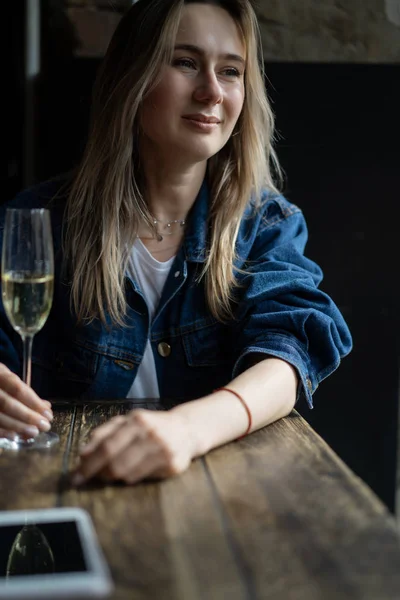Joven hermosa mujer en un café, una mujer bebiendo champán en un —  Fotos de Stock
