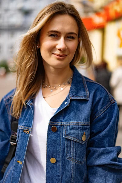 Genç, güzel bir kadın Avrupa 'da şehirde dolaşıyor, sokak fotoğrafı, şehir merkezinde poz veren bir kadın.