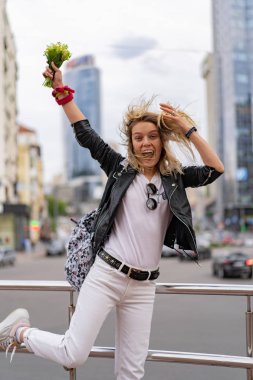 Genç, güzel bir kadın Avrupa 'da şehirde dolaşıyor, sokak fotoğrafı, şehir merkezinde poz veren bir kadın.