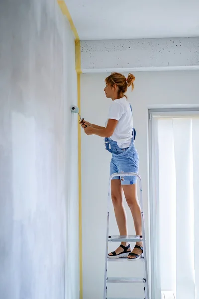 Giovane Bella Donna Riparazioni Appartamento Dipinge Pareti Con Rullo Lavori — Foto Stock