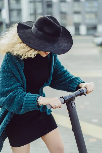 İşe elektrikli scooterla giden genç, güzel bir kadın, modern kız, yeni nesil, elektrik nakli, ekolojik ulaşım, ekolojik ulaşım, gün batımı