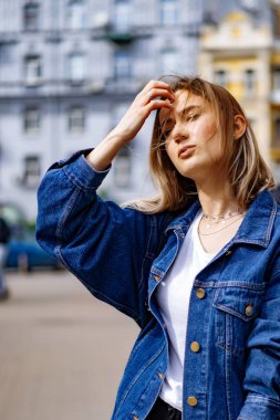 Genç, güzel bir kadın Avrupa 'da şehirde dolaşıyor, sokak fotoğrafı, şehir merkezinde poz veren bir kadın.