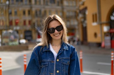 Genç, güzel bir kadın Avrupa 'da şehirde dolaşıyor, sokak fotoğrafı, şehir merkezinde poz veren bir kadın.