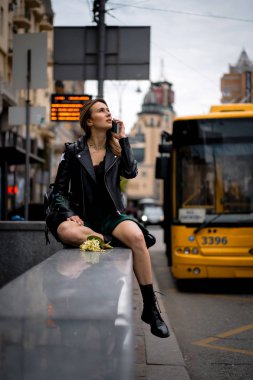 Genç, güzel bir kadın Avrupa 'da şehirde dolaşıyor, sokak fotoğrafı, şehir merkezinde poz veren bir kadın.