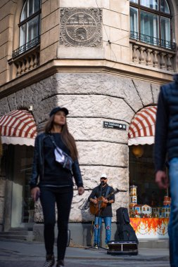 Sokak müzisyeni. Bir adam gitar çalar ve mikrofona şarkı söyler..