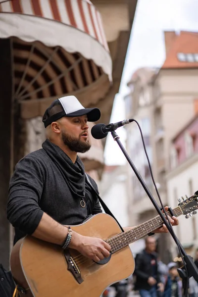 ストリートミュージシャン 男がギターを弾き 街の通りでマイクに向かって歌う — ストック写真