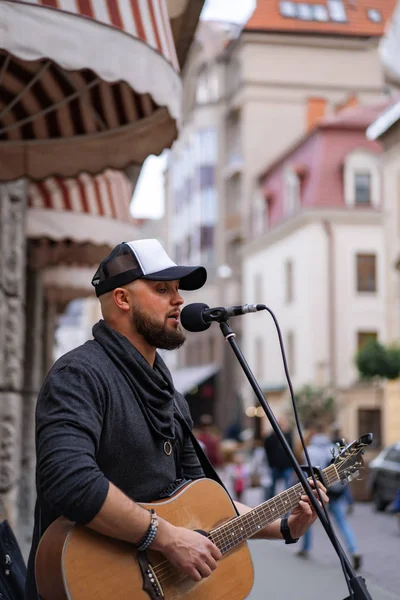 ストリートミュージシャン 男がギターを弾き 街の通りでマイクに向かって歌う — ストック写真