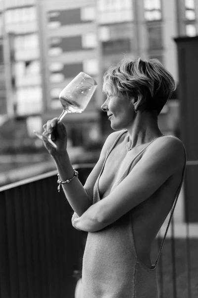 ワインのガラスとテラスで美しい女性は 笑って休んでいる 白黒写真です — ストック写真