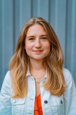 Kırmızı elbiseli, mavi gözlü güzel sarışın kadın, mutlu bir gülümseme. Yaz. Dışarda yakın plan portre