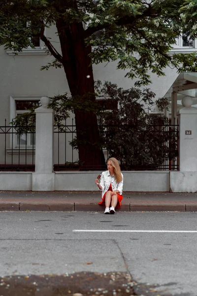 Bela Jovem Mulher Vestido Vermelho Uma Jaqueta Ganga Branca Comendo — Fotografia de Stock