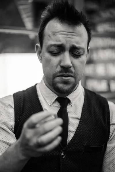 young emotional charismatic man with a cigarette. Attractive man smokes. Emotional man portrait. close-up. black and white portrait of bartender