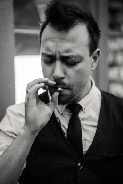 young emotional charismatic man with a cigarette. Attractive man smokes. Emotional man portrait. close-up. black and white portrait of bartender