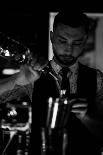 Young emotional charismatic male bartender at work in a bar.