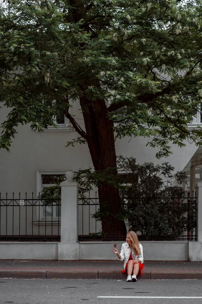 Kırmızı Elbiseli Beyaz Kot Ceketli Güzel Bir Kadın Çubukta Dondurma — Stok fotoğraf