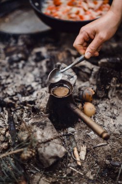 Turk 'de bir kamp gezisinde kazıkta yapılan kahve. Mutfakta kamp yapmak, ormanda ateş yakmak. Kampanyadaki yaşam konsepti.